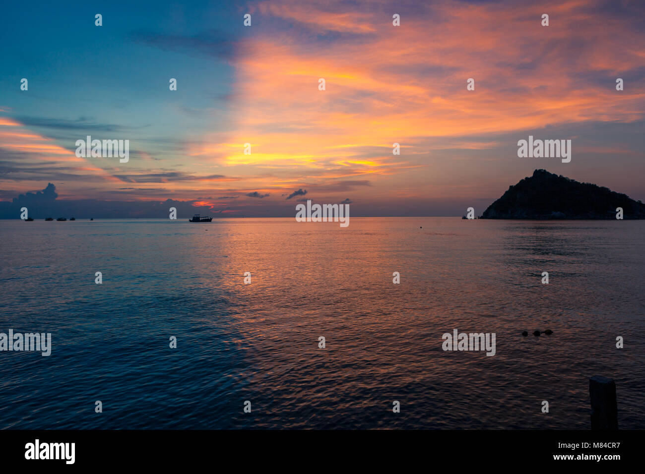 Incredibile tramonto con metà blu e metà giallo arancione e rosa cielo sopra il mare e le navi di oltre l'orizzonte. Vista dell'Isola Nang Yuan da Ko Tao Foto Stock