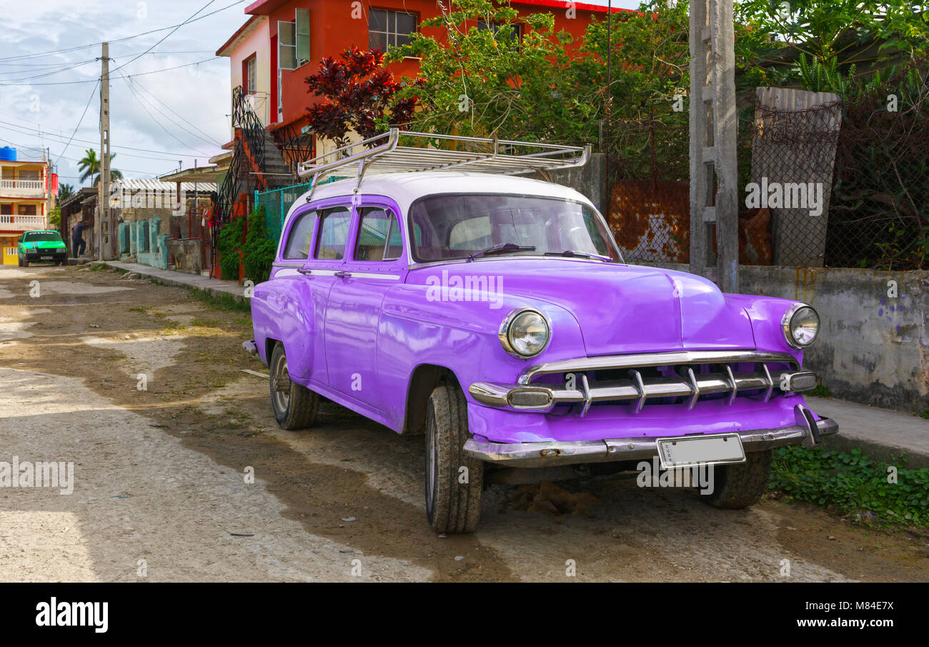 Viola e bianco auto d'epoca in una piccola città in Cuba Foto Stock