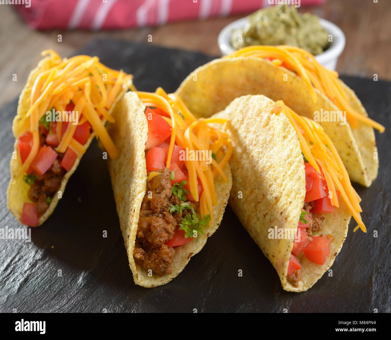 Tacos con carne di manzo macinata, formaggio, verdure e salsa guacamole Foto Stock