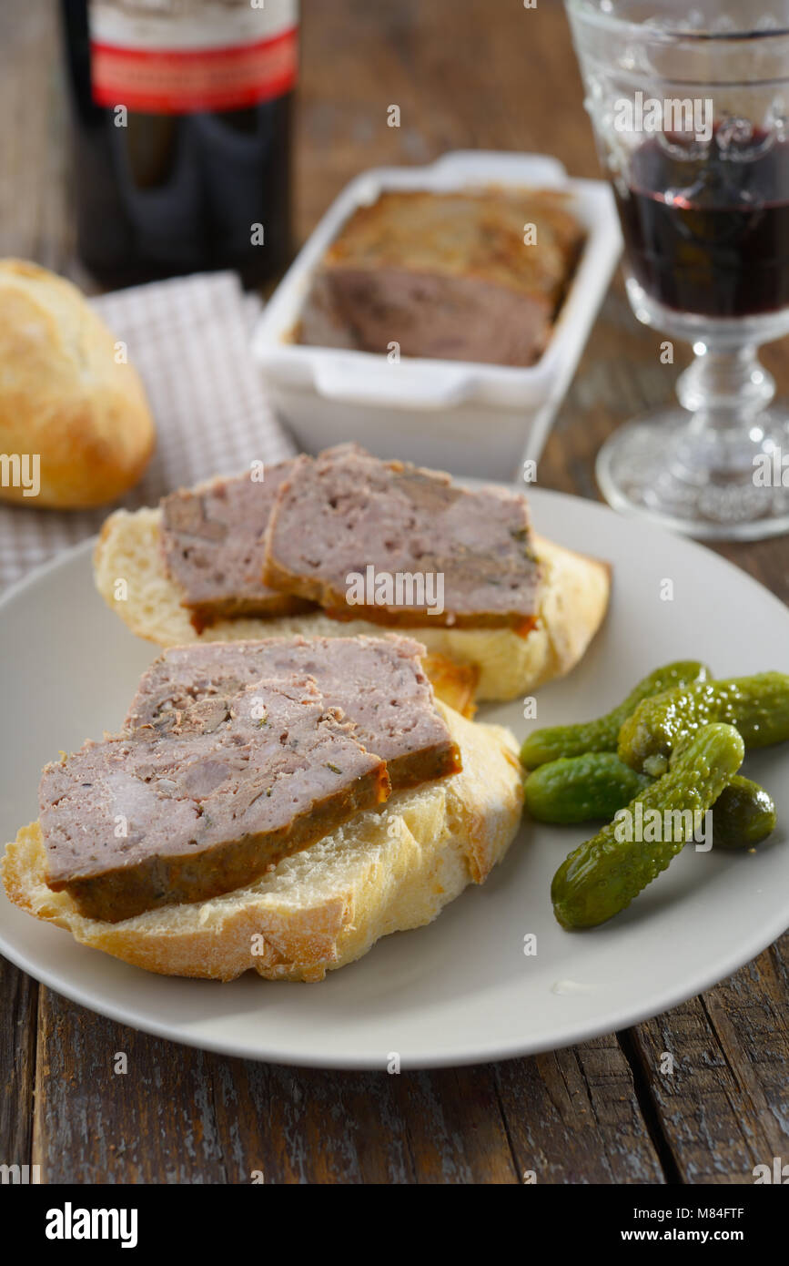Panini con terrina e cetriolini su un piatto servito Rith vino rosso Foto Stock