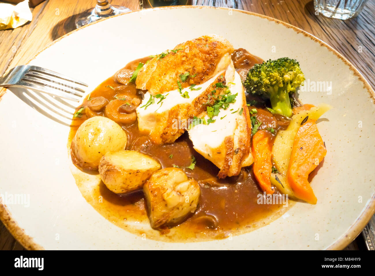 Pranzo in un ristorante francese in Inghilterra tradizionale Chasseur di pollo con verdure e patate Foto Stock