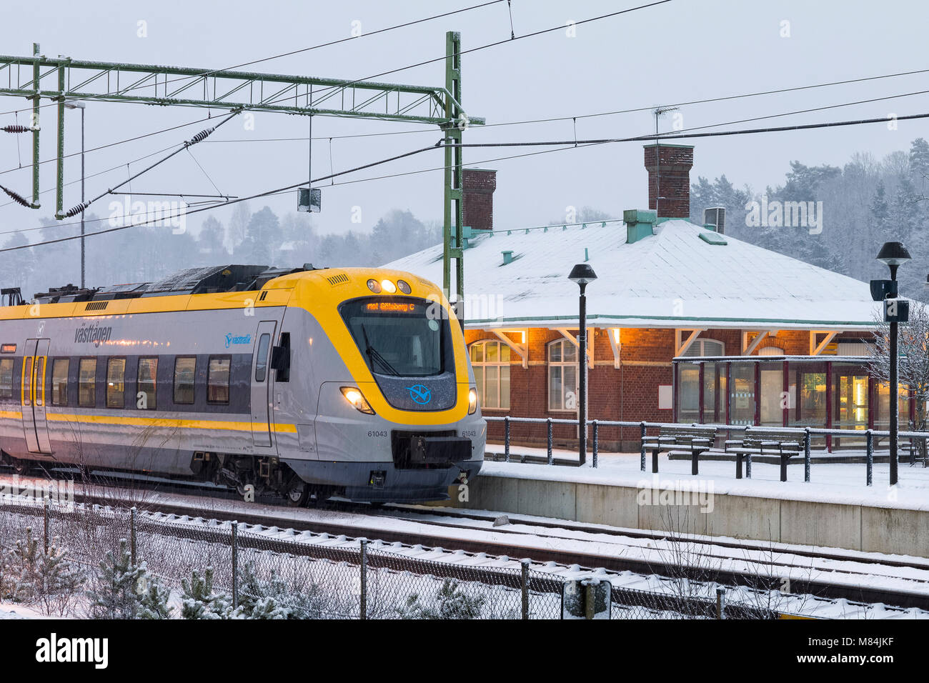 FLODA, Svezia - 16 febbraio: Moderna commuter rail treno passeggeri o ferrovia suburbana a stazione ferroviaria di neve durante l'inverno modello di rilascio: No. Proprietà di rilascio: No. Foto Stock