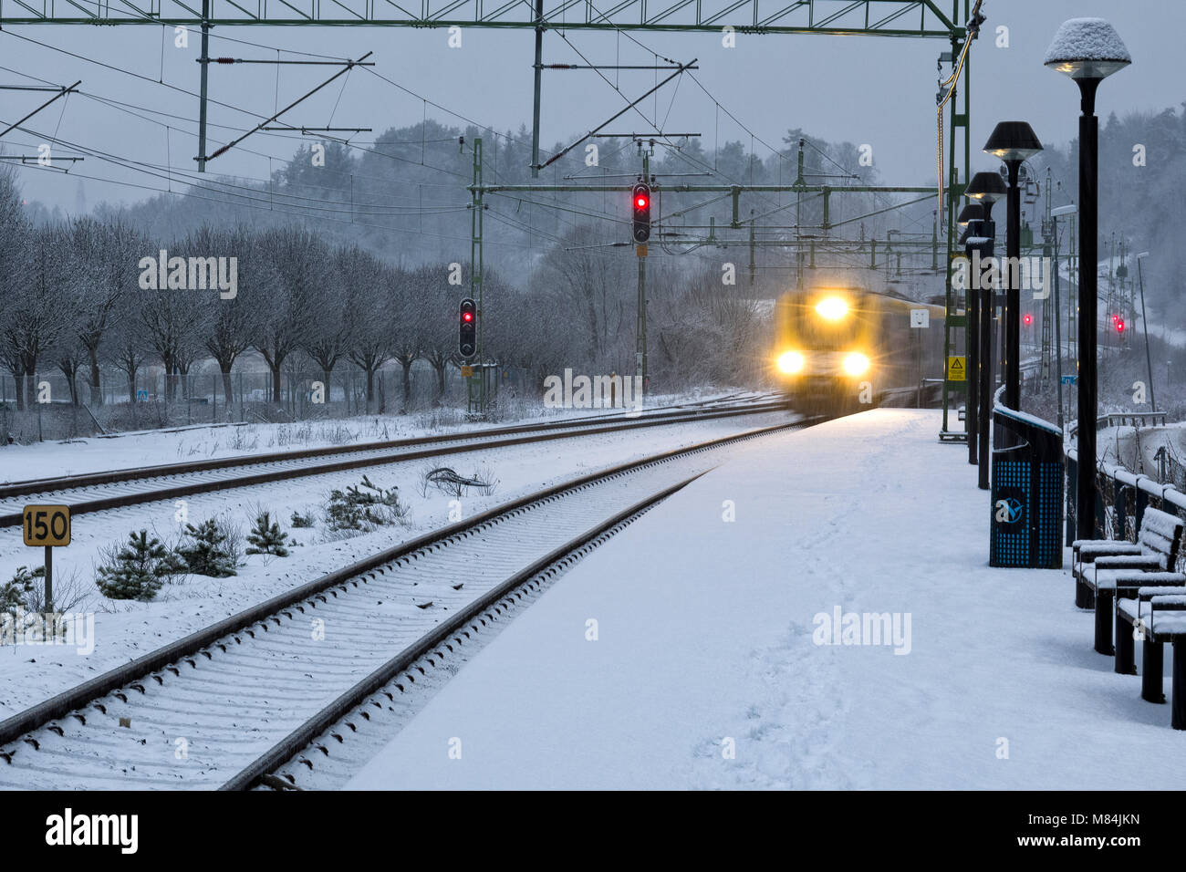 FLODA, Svezia - 16 febbraio: Moderna commuter rail treno passeggeri o ferrovia suburbana nella neve durante l'inverno stazione ferroviaria modello di rilascio: No. Proprietà di rilascio: No. Foto Stock