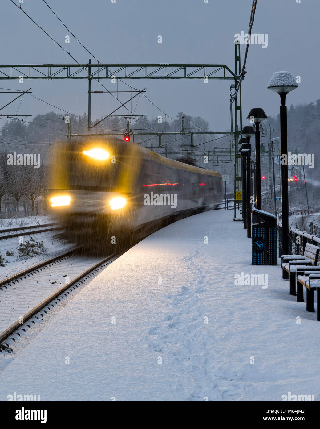 FLODA, Svezia - 16 febbraio: Moderna commuter rail treno passeggeri o ferrovia suburbana nella neve durante l'inverno stazione ferroviaria modello di rilascio: No. Proprietà di rilascio: No. Foto Stock