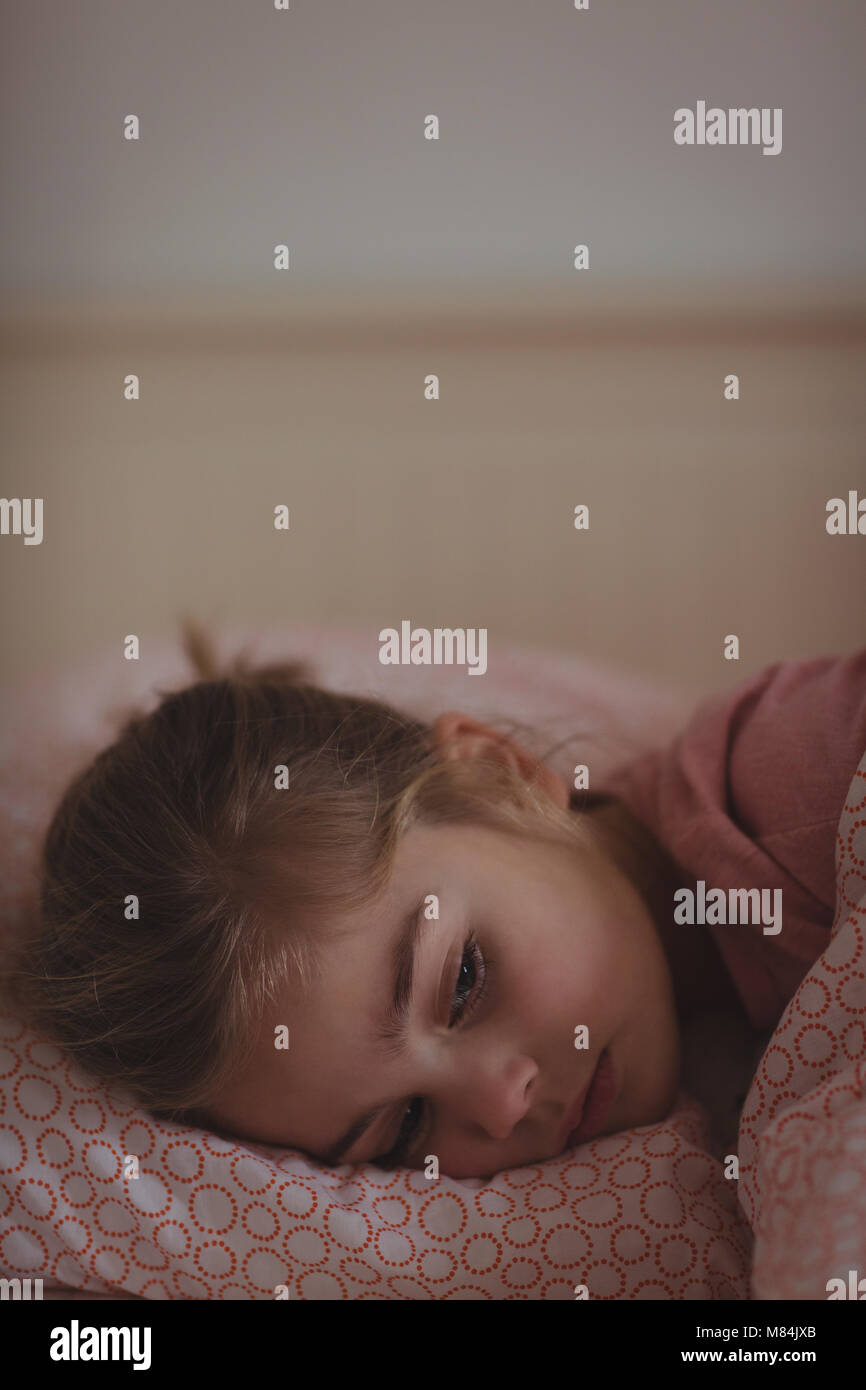 Ragazza dorme sul letto in camera da letto a casa Foto Stock