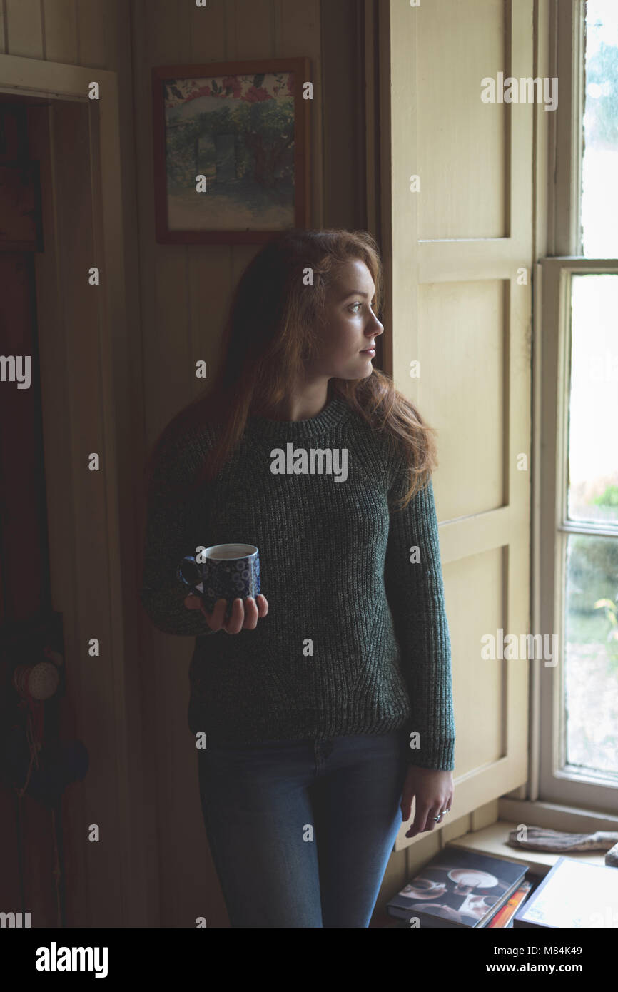 Donna con il caffè a casa Foto Stock