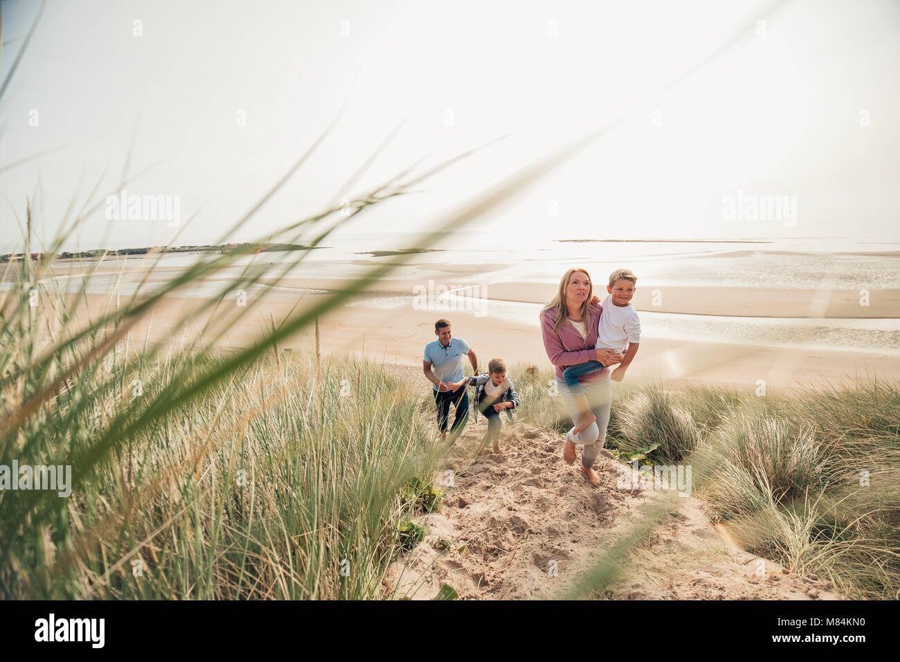 Famiglia con due ragazzini a piedi fino alla duna di sabbia. Foto Stock