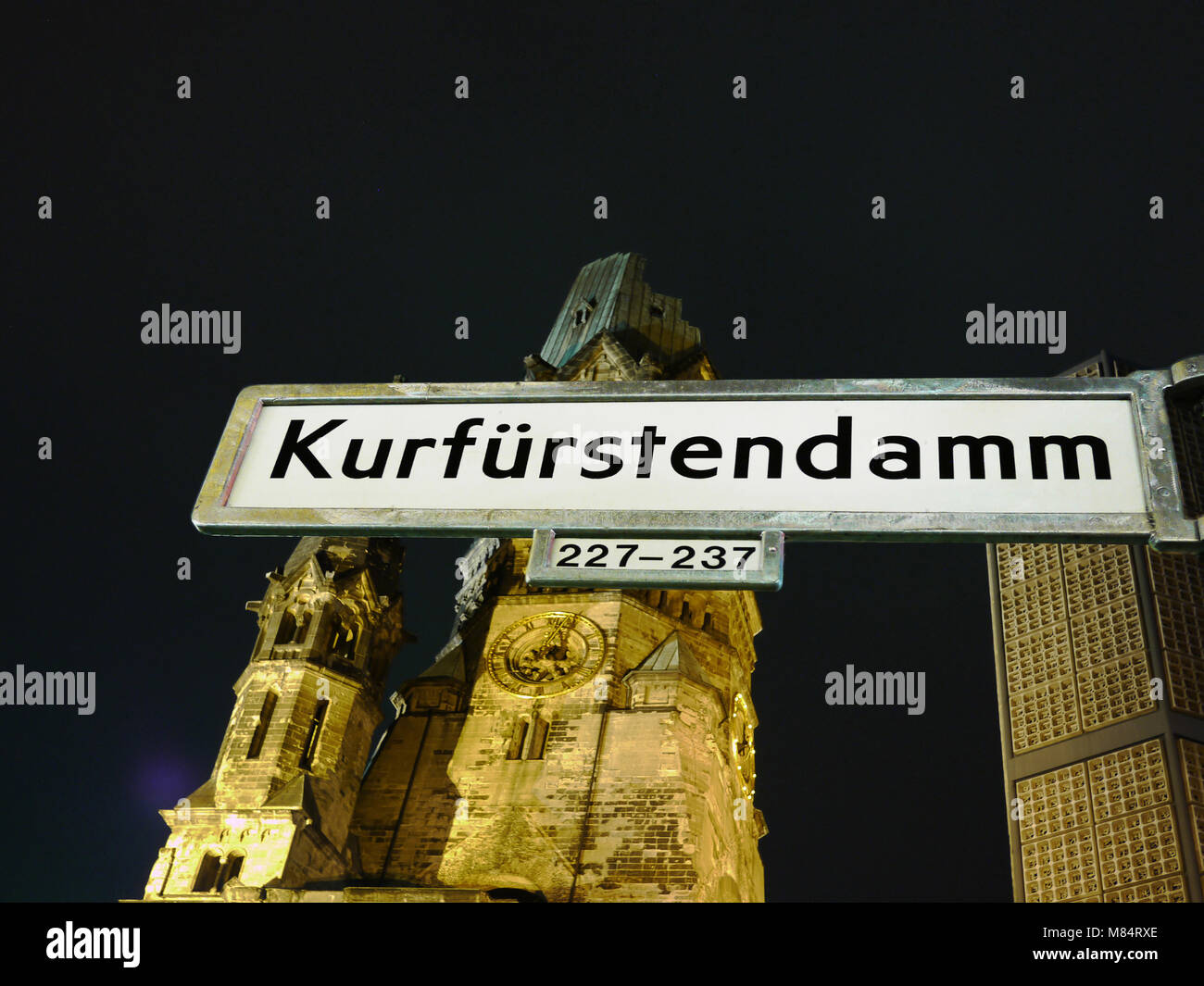 Berlino, la Kaiser Wilhelm Memorial Church di notte di fronte ad essa il segno di strada berlinese di strada più famosa Foto Stock