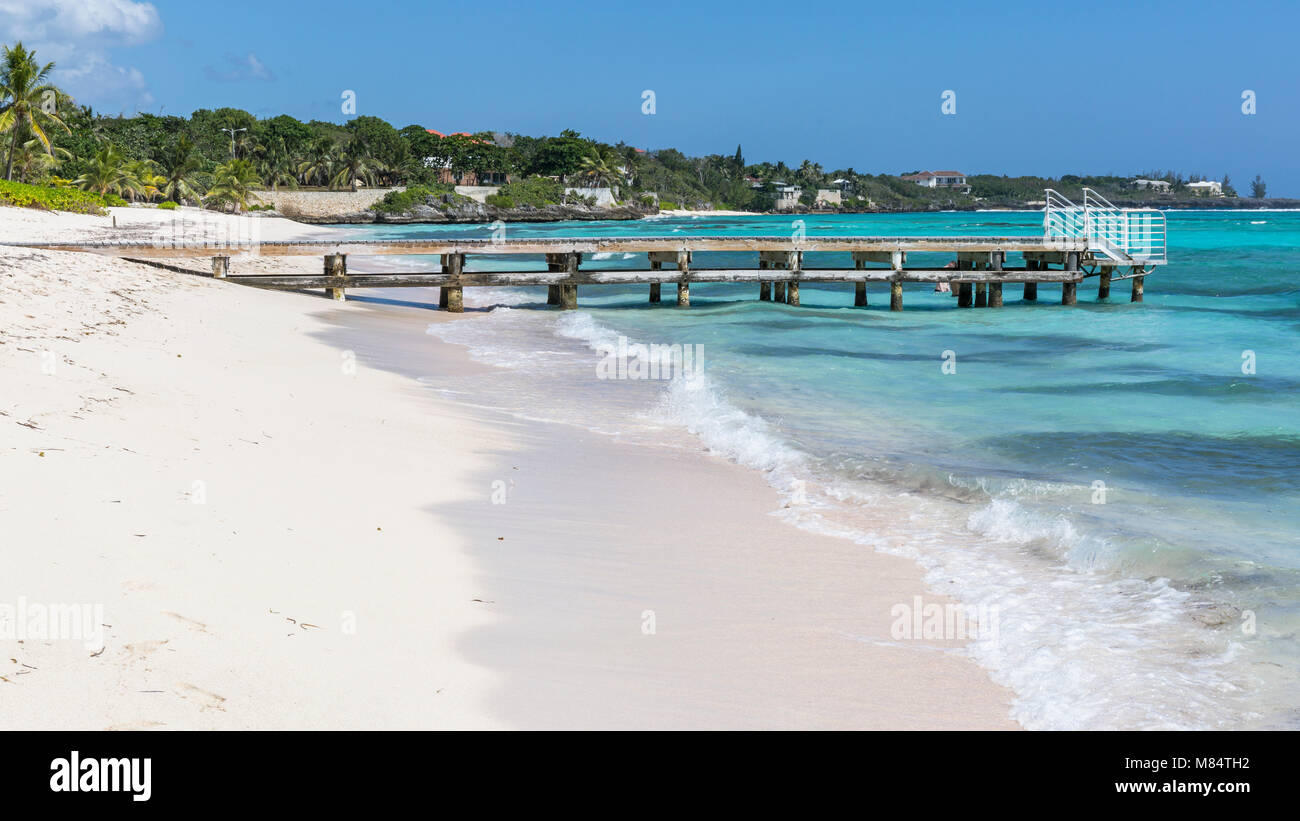 Un molo in legno sporge nella i Caraibi sul Spotts Beach a Savannah sul lato sud di Grand Cayman, Isole Cayman Foto Stock