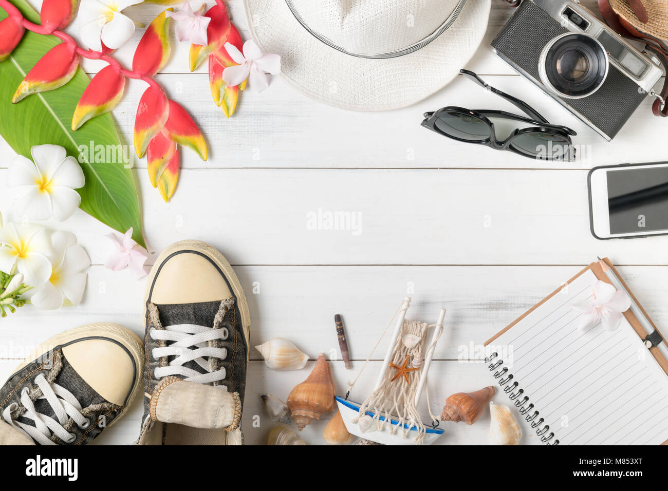 Preparare gli accessori e articoli da viaggio per l'estate, cappello, occhiali da sole e fotocamera vintage, sneaker, su bianco tavola di legno, piatto di laici che, vista dall'alto lo sfondo Foto Stock