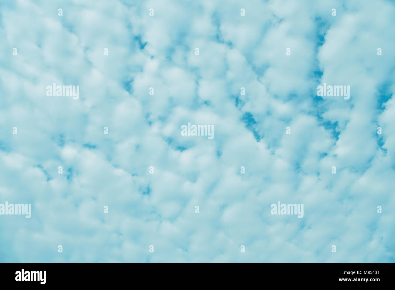 La lana come puffy nuvole bianche con tracce di cielo blu su un nuvoloso giorno Foto Stock
