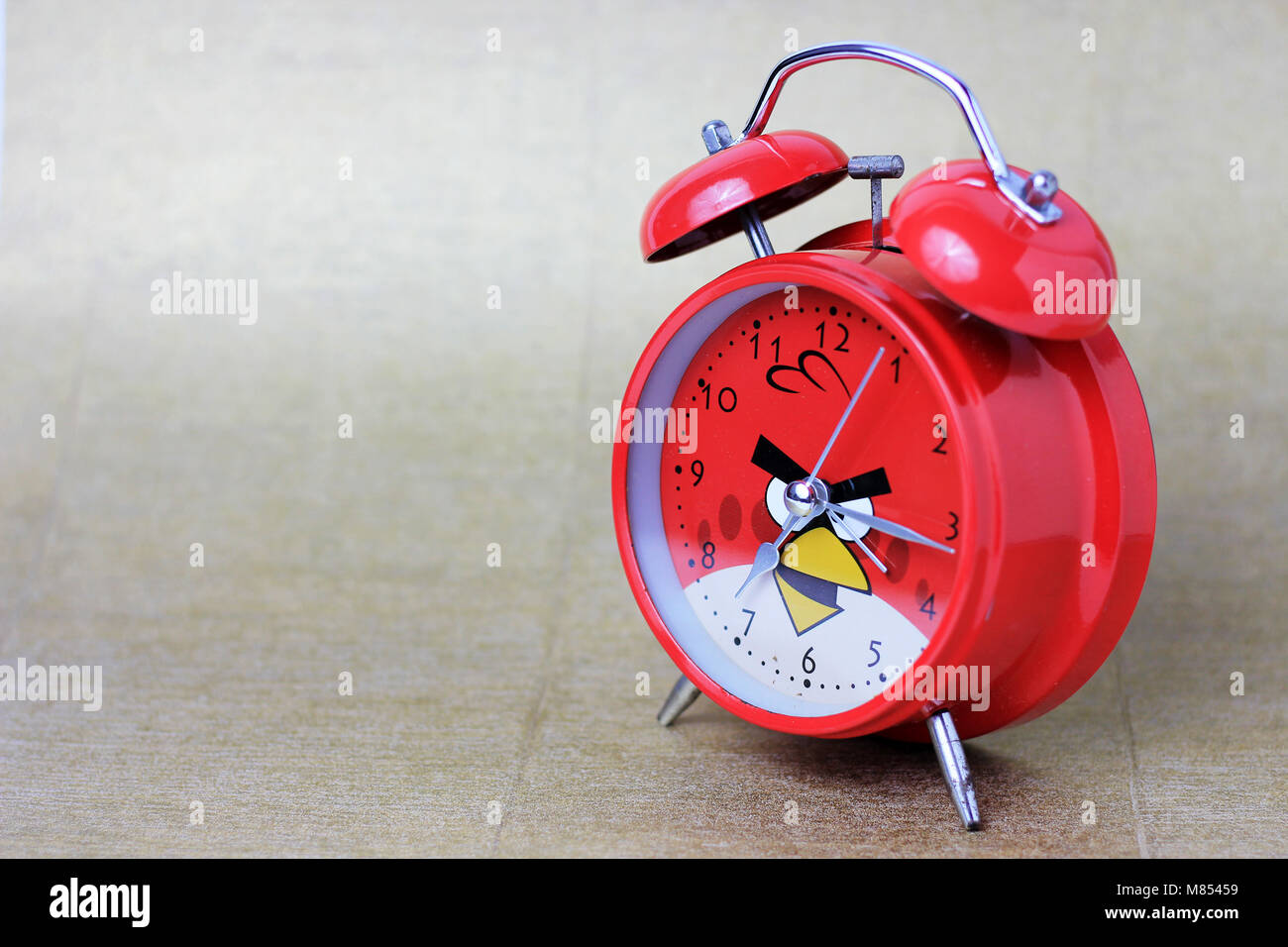 Una sveglia rossa con uno sfondo marrone è sfocata, posizionato a destra Foto Stock