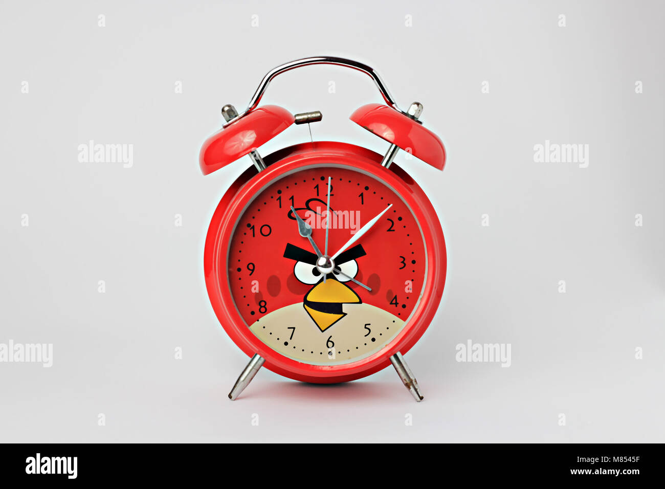 Una sveglia rossa con sfondo bianco, posizione centrale Foto Stock