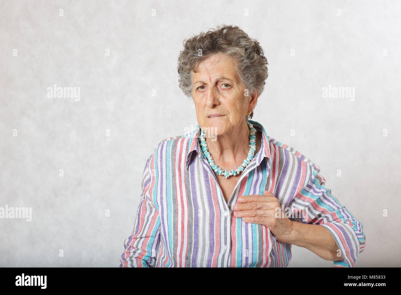 Vecchia donna tra 70 e 80 soffre di un dolore nel suo cuore. Spazio libero per un testo Foto Stock