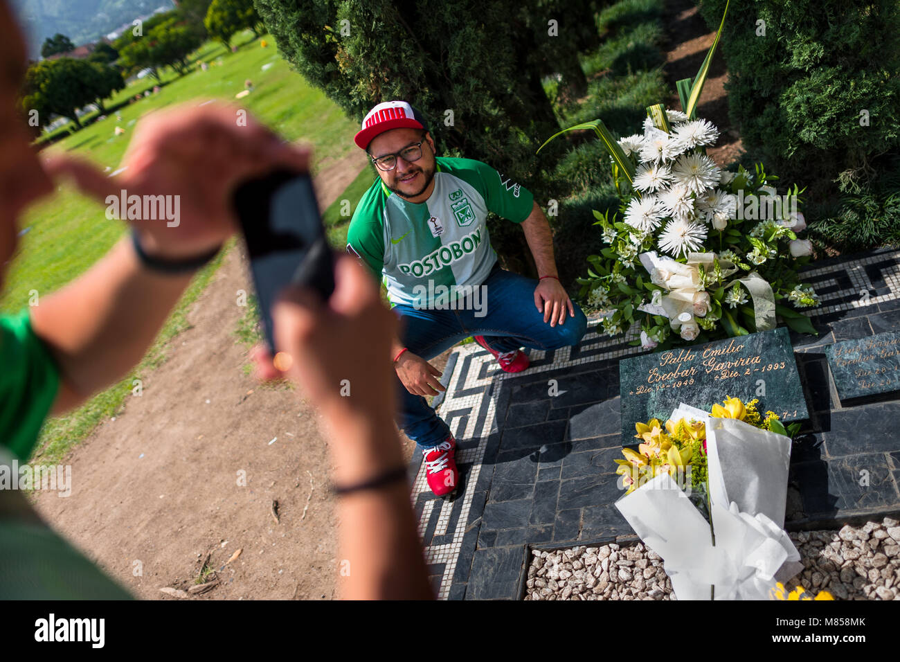 Giovani uomini colombiano di scattare istantanee di se stessi durante la visita alla tomba del signore di droga Pablo Escobar nel cimitero di Itagüí, Colombia. Foto Stock