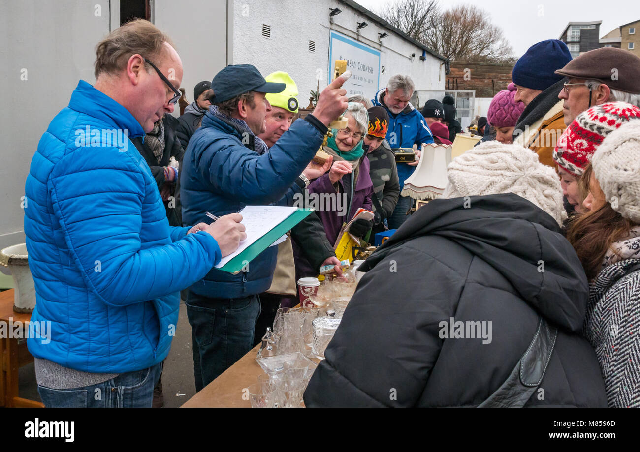 Persone a lane vendita tabella d'aste, Ramsey Cornish, Jane Street, Leith, Edimburgo, Scozia, banditore tenendo premuto fino candlesitcks Foto Stock