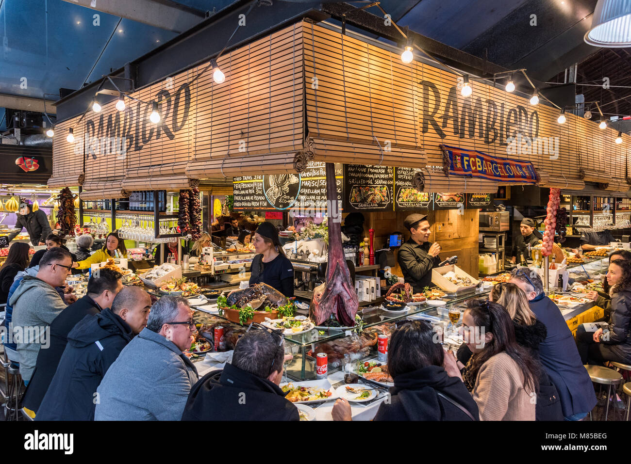 I turisti di mangiare in un bar di tapas a Mercato di Boqueria, Barcellona, in Catalogna, Spagna Foto Stock