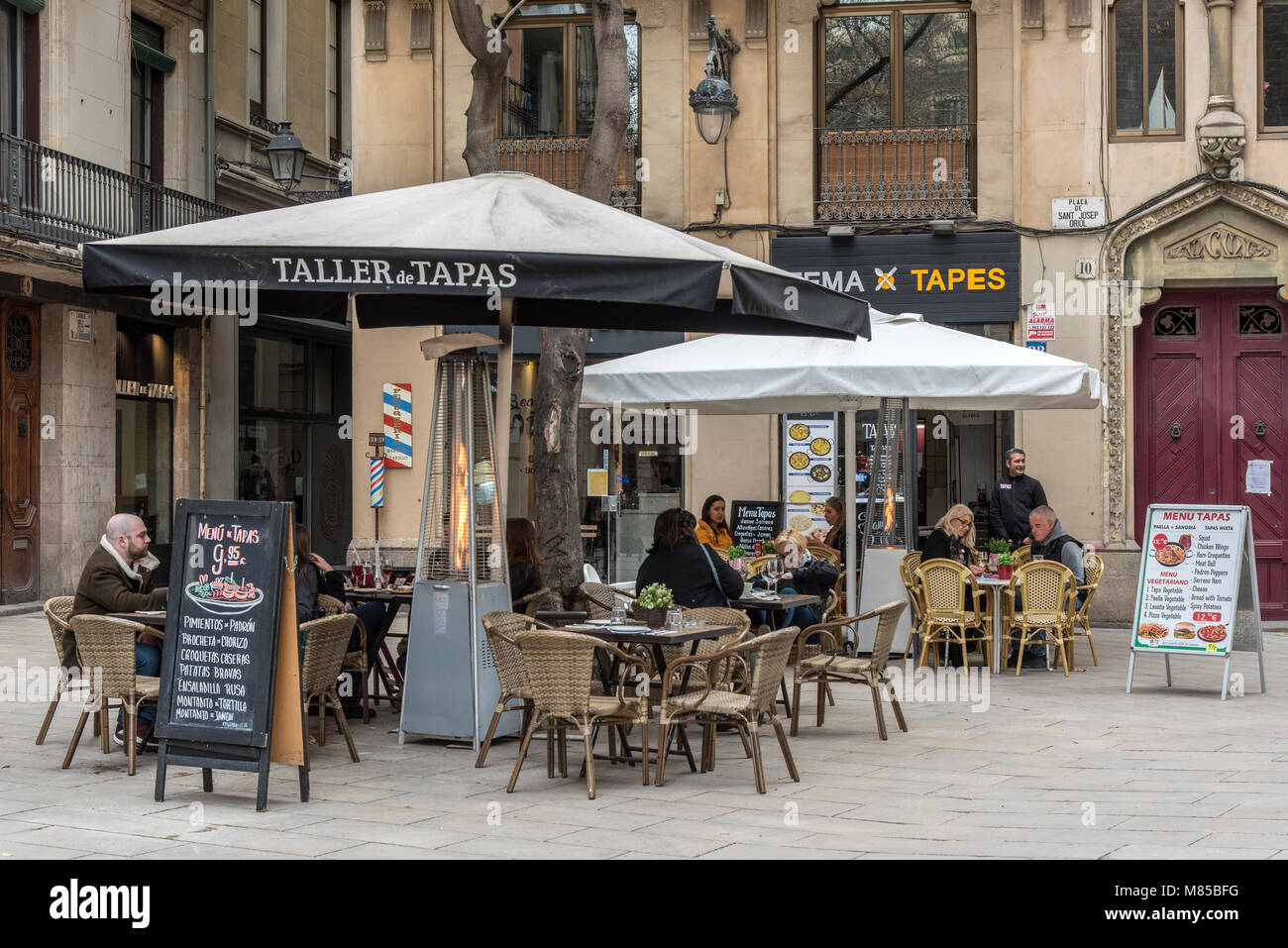 Outdoor cafe con i turisti seduti ai tavoli nel quartiere Gotico di Barcellona, in Catalogna, Spagna Foto Stock