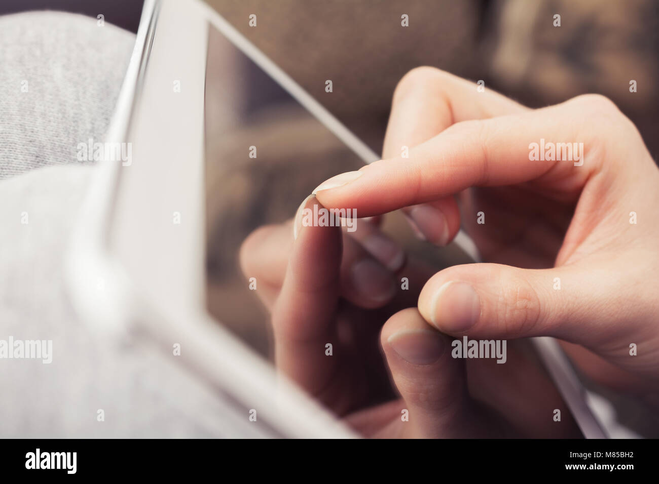 Mano femmina facendo gesto di Zoom sul display Tablet Foto Stock