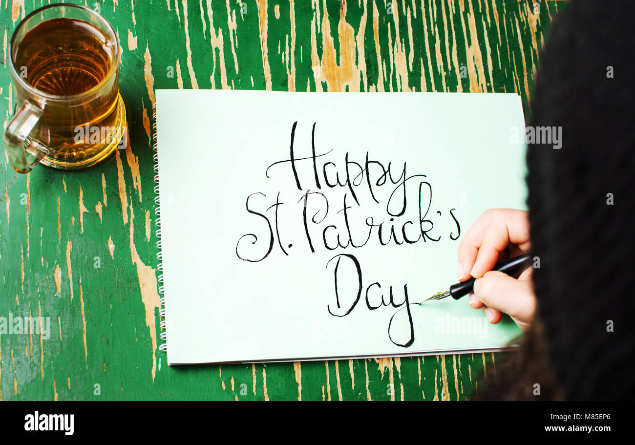 L'uomo la scrittura di un felice St Patrick giorno scheda di calligrafia Foto Stock