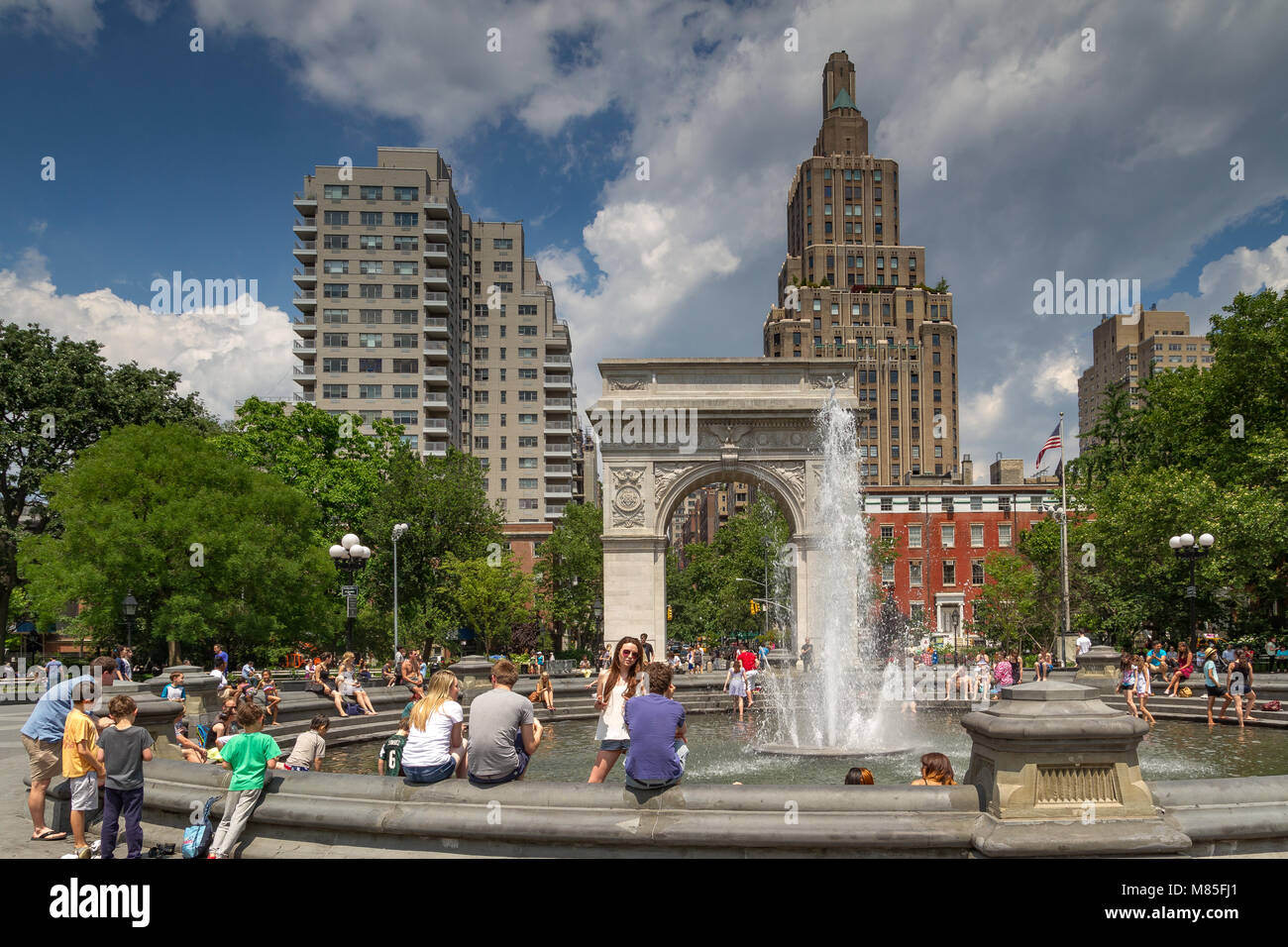La gente siede intorno alla fontana al Washington Square Park in una calda giornata estiva nel Greenwich Village, Manhattan, New York City Foto Stock