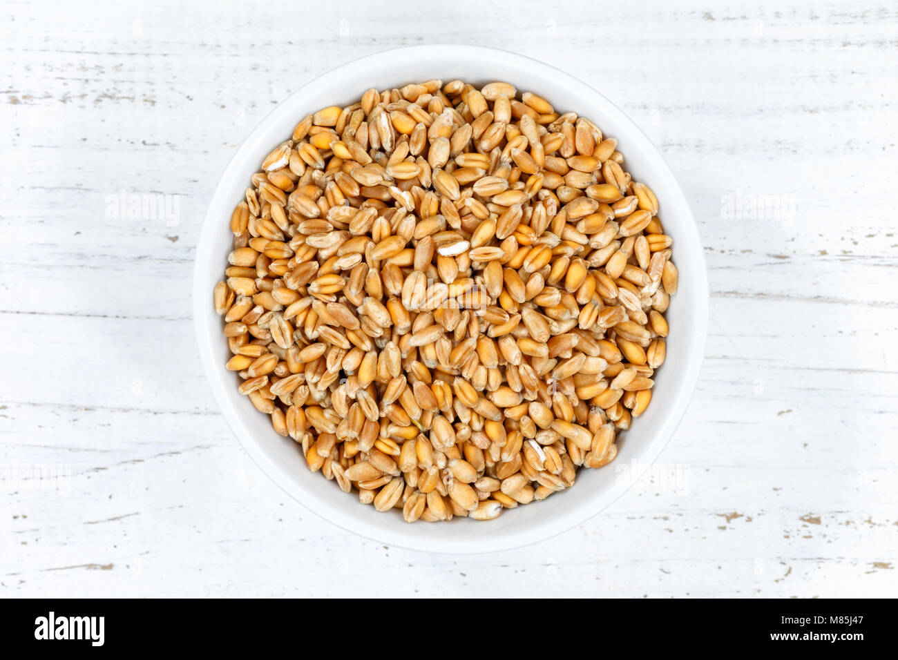 Grano grani da sopra ciotola di legno di legno della scheda Foto Stock