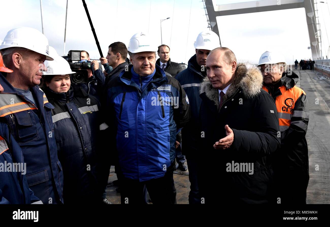 Il presidente russo Vladimir Putin parla con i lavoratori durante un tour della strada-ferrovia ponte che collega la Crimea alla Russia continentale Marzo 14, 2018 vicino a Kerch Crimea. Il ponte è parte della strategia di finalizzare l'annessione della Crimea Foto Stock