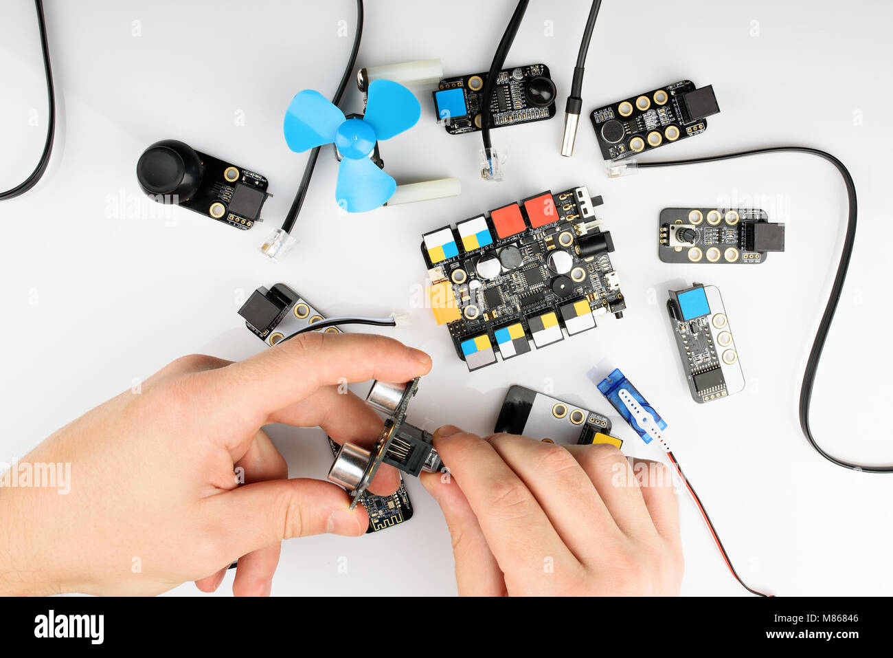 Costruzione di Robot kit sopra vista. Mani ASSEMBLAGGIO DI QUADRI ELETTRICI Foto Stock