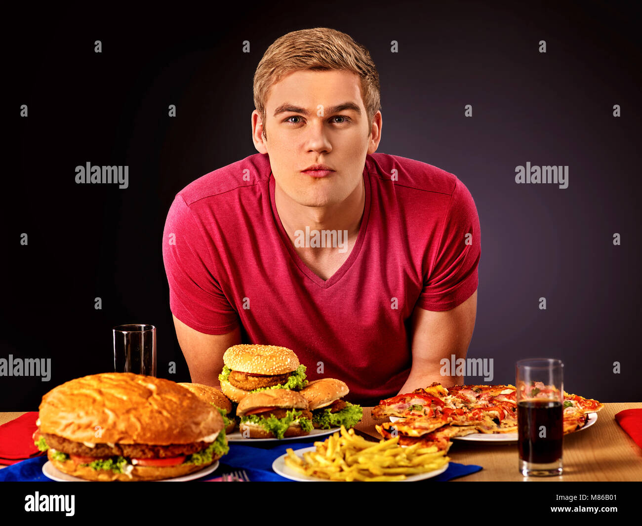 Donna di mangiare hamburger. Studente consumano fast food. Foto Stock