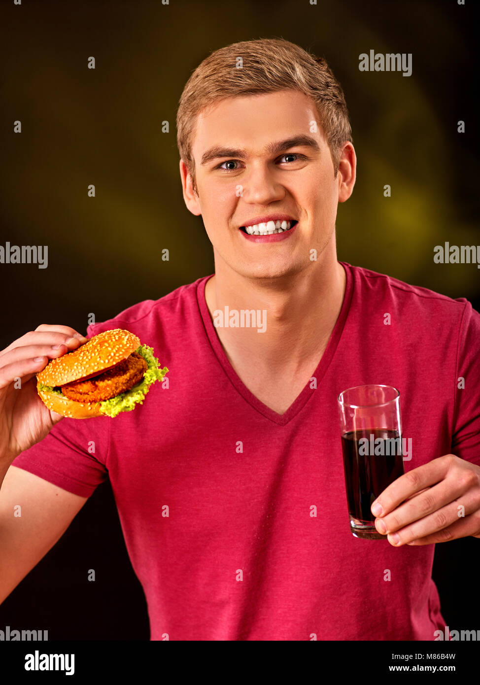 Uomo di mangiare pizza e bere . Studente consumano fast food. Foto Stock