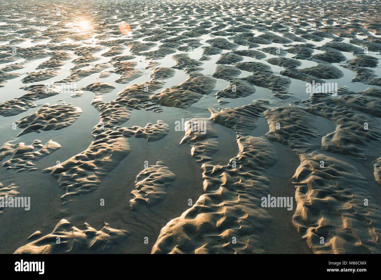 Bella la luce del sole, sabbia e acqua formare strutture Foto Stock