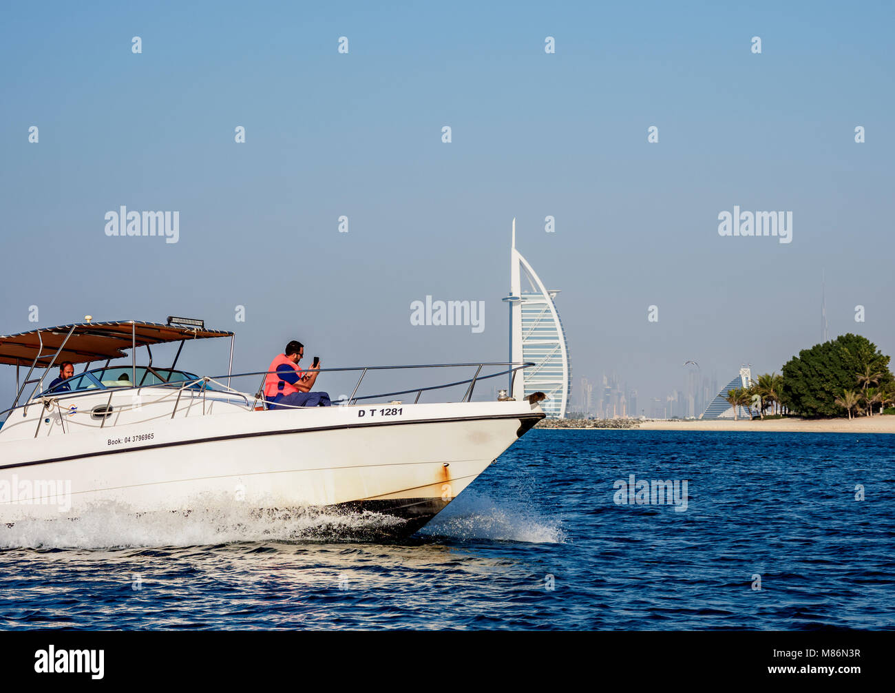 Yacht sul Golfo Persico con il Burj Al Arab Hotel di lusso in background, Dubai, Emirati Arabi Uniti Foto Stock