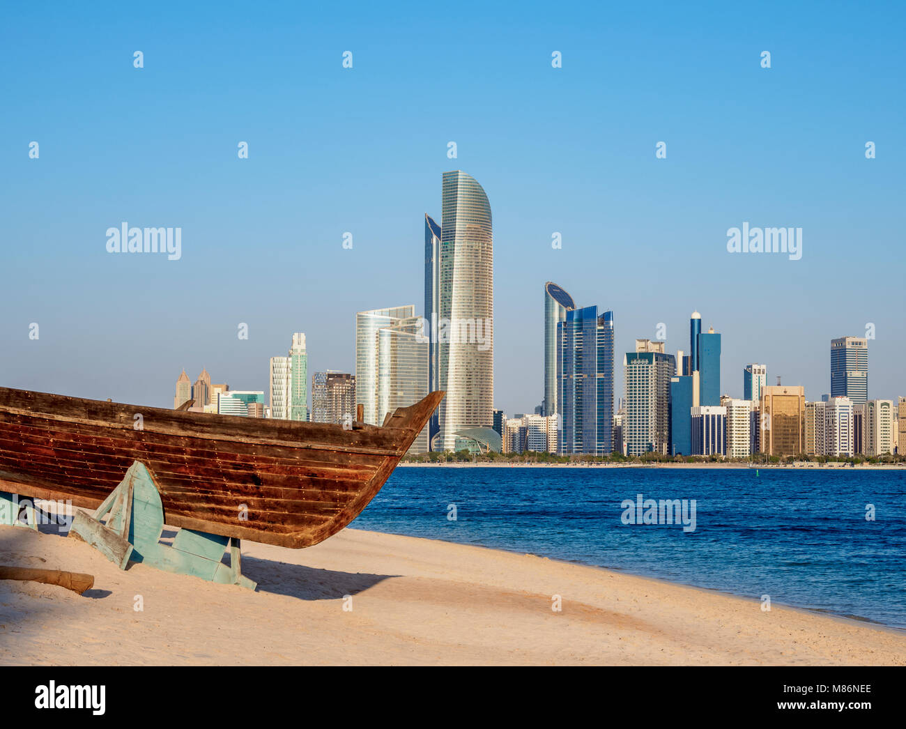 Barca tradizionale nel Villaggio del Patrimonio Culturale con lo skyline della città in background, Abu Dhabi, Emirati Arabi Uniti Foto Stock