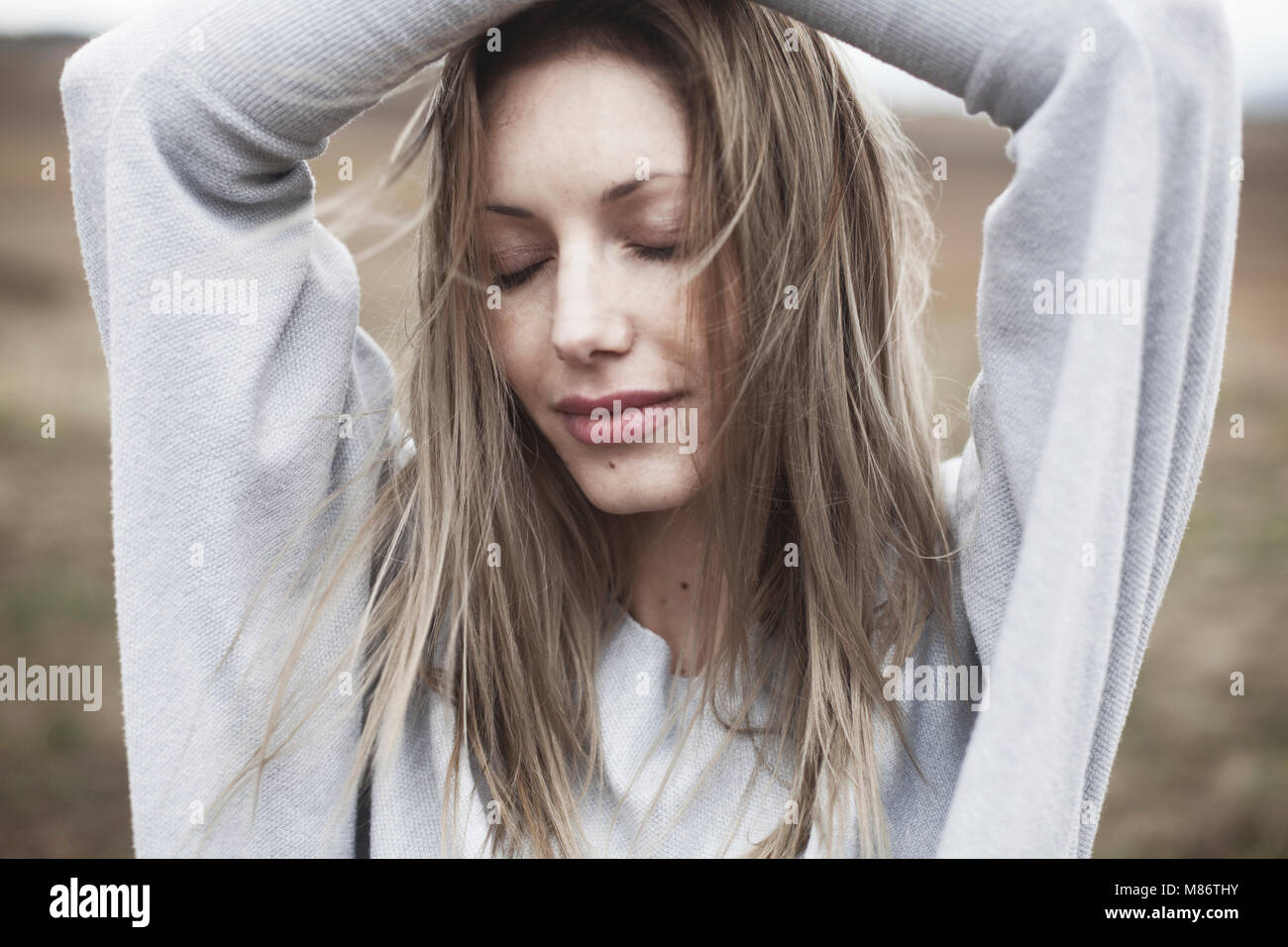 Ritratto di una donna con le mani sul suo capo Foto Stock