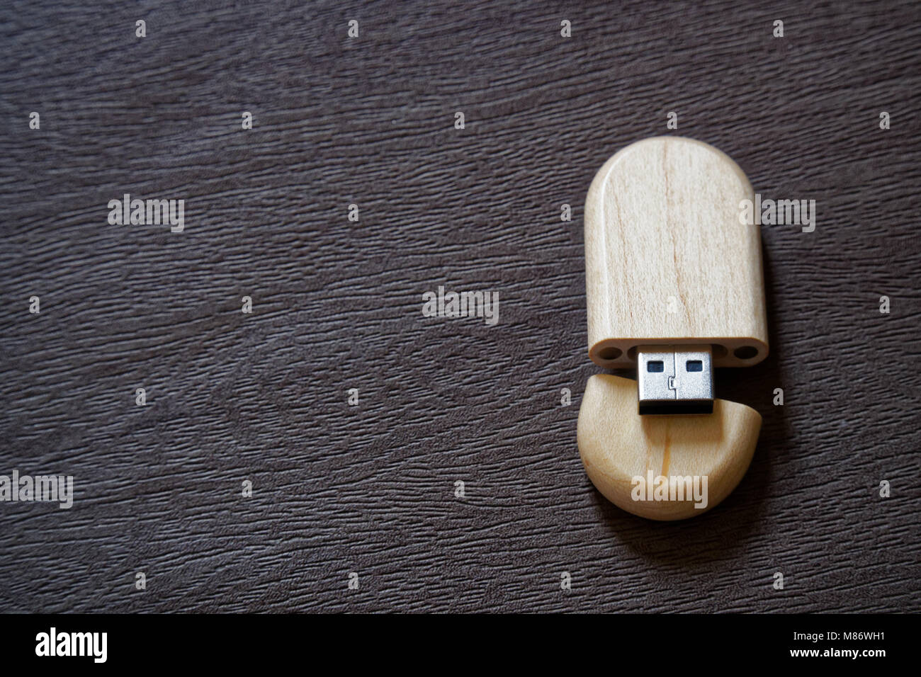 Drive flash USB con superficie in legno sulla scrivania per porta USB plug-in computer portatile per il trasferimento di dati e backup business concetto. Foto Stock