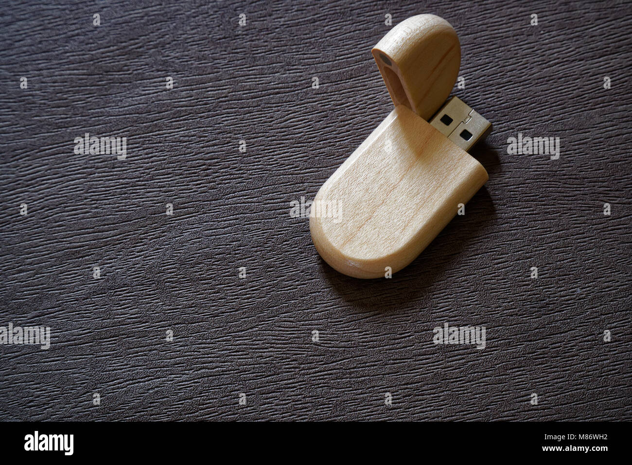 Drive flash USB con superficie in legno sulla scrivania per porta USB plug-in computer portatile per il trasferimento di dati e backup business concetto. Foto Stock