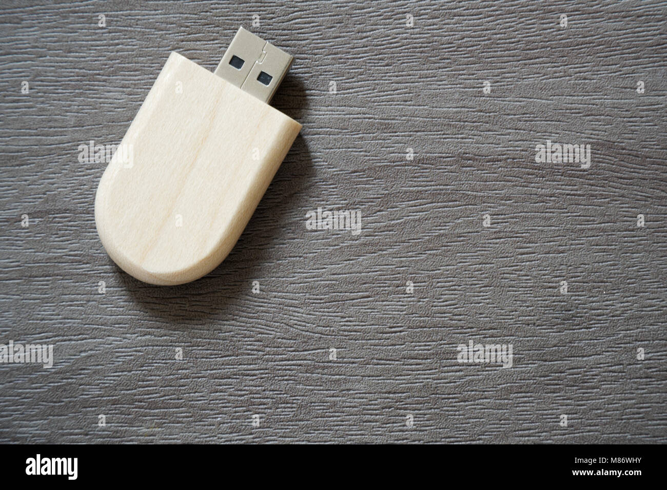 Drive flash USB con superficie in legno sulla scrivania per porta USB plug-in computer portatile per il trasferimento di dati e backup business concetto. Foto Stock