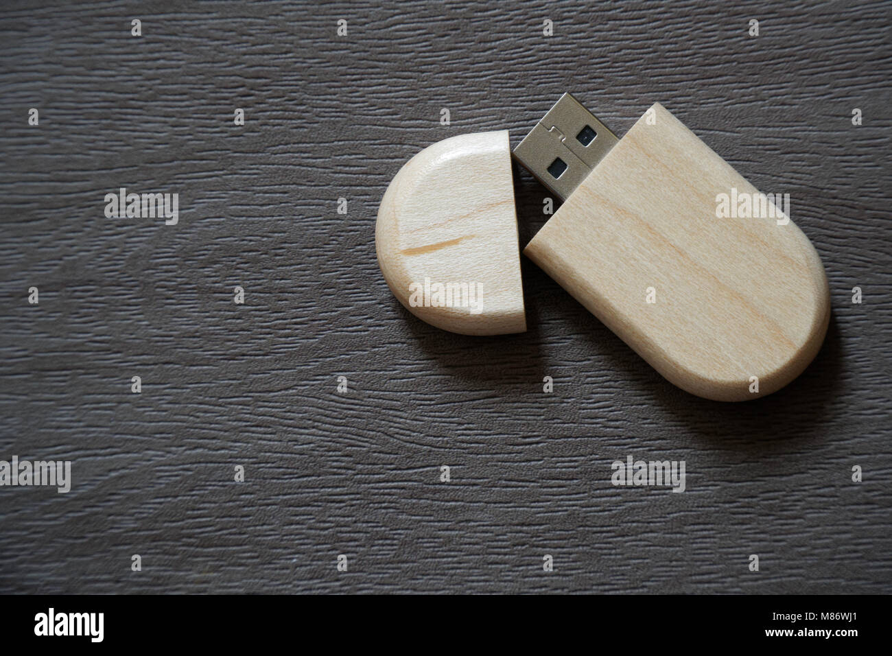 Drive flash USB con superficie in legno sulla scrivania per porta USB plug-in computer portatile per il trasferimento di dati e backup business concetto. Foto Stock