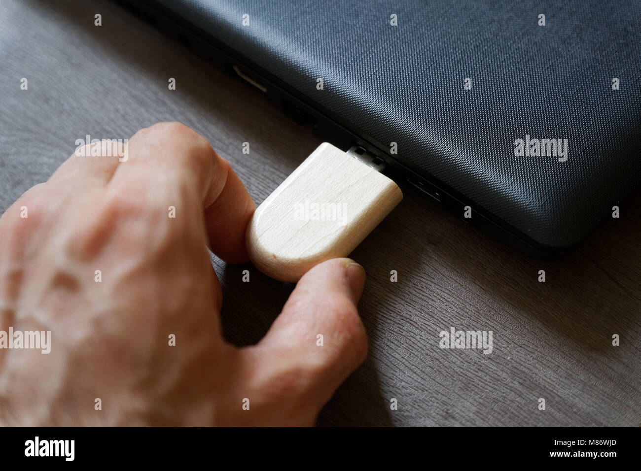 Mano inserire unità flash USB collegati alla porta USB plug-in computer portatile per il trasferimento di dati e backup business concetto. Foto Stock