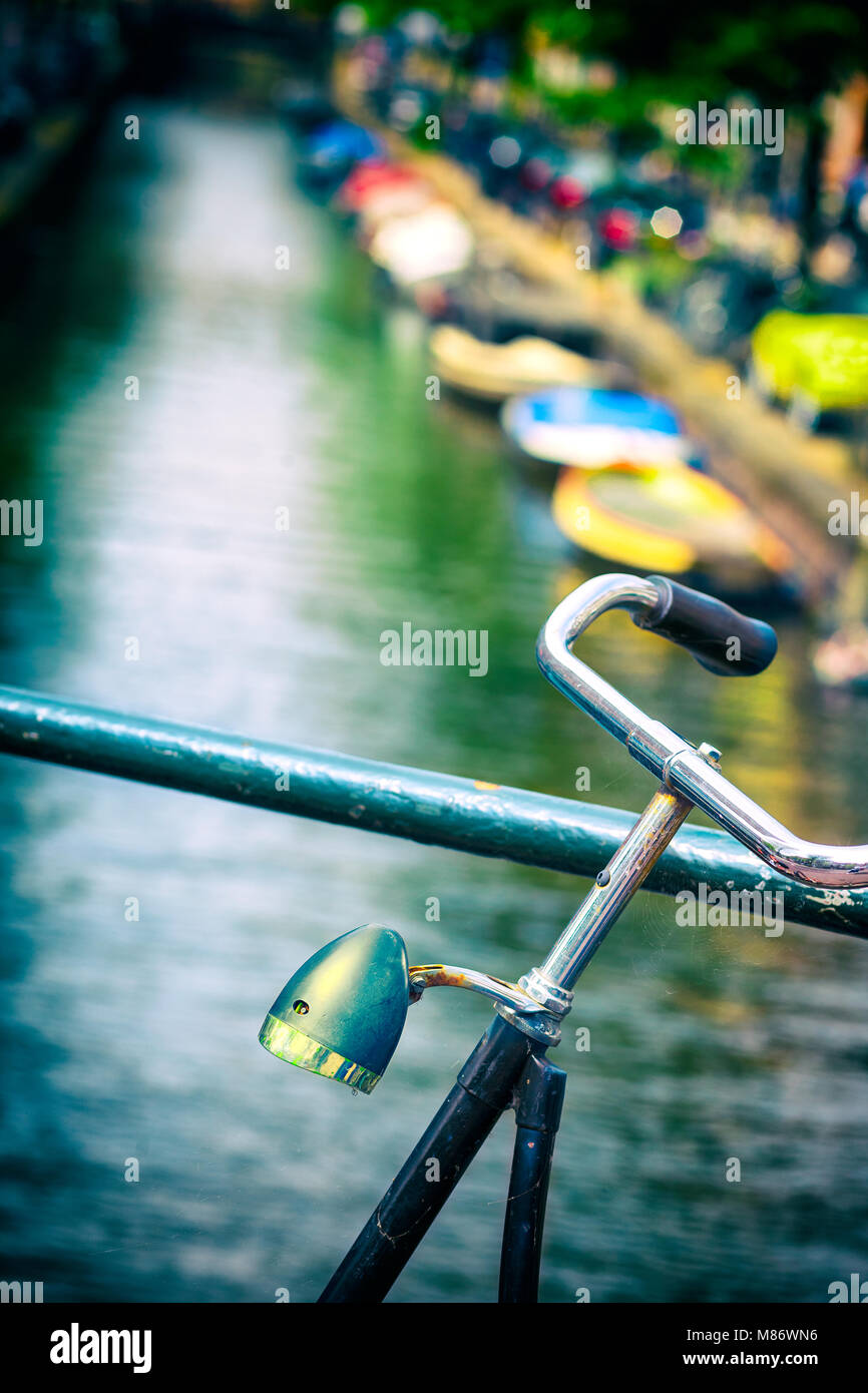 Bicicletta parcheggiata da un canale, Amsterdam, Olanda Foto Stock