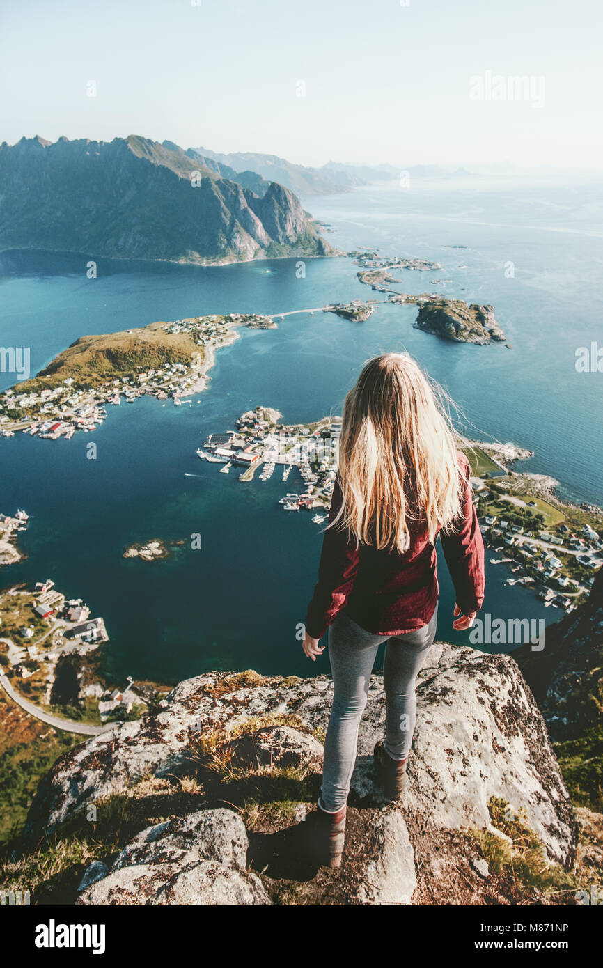 Giovane donna in Norvegia in piedi da sola sulla scogliera dello stile di vita di Montagna Esplorazione Avventura concetto all'aperto estate vacanze isole Lofoten Foto Stock