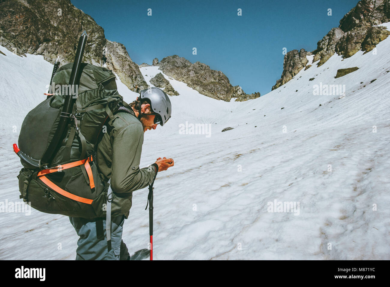 L'uomo avventuriero con tracker gps navigator controllando le coordinate di una posizione di arrampicata in montagna spedizione in viaggio di sopravvivenza il concetto di stile di vita all'aperto Foto Stock