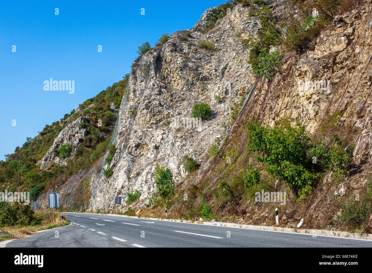 Strada di Montagna in Macedonia. Alta roccia protetti da rete in acciaio.  Paesaggio con Colline variopinte coperte da foreste Foto stock - Alamy