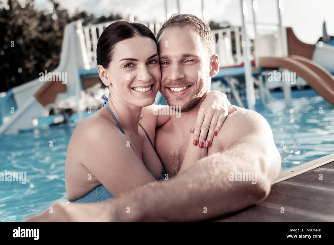 Amare la millenaria giovane abbracciando in piscina Foto Stock