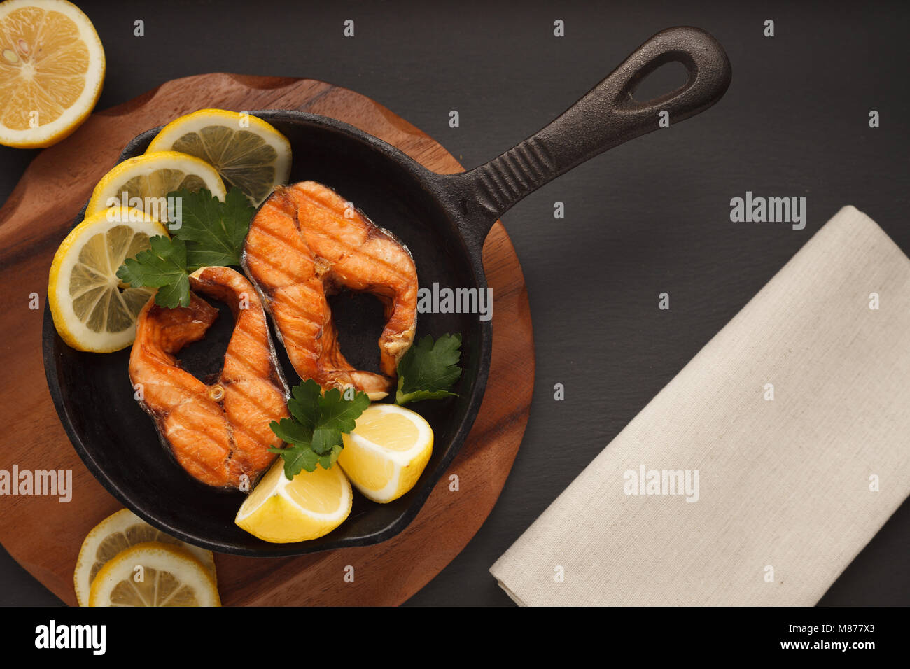 Fritti o filetto di salmone alla griglia su cast-padella di ferro con pane e limone. Flatlay Foto Stock