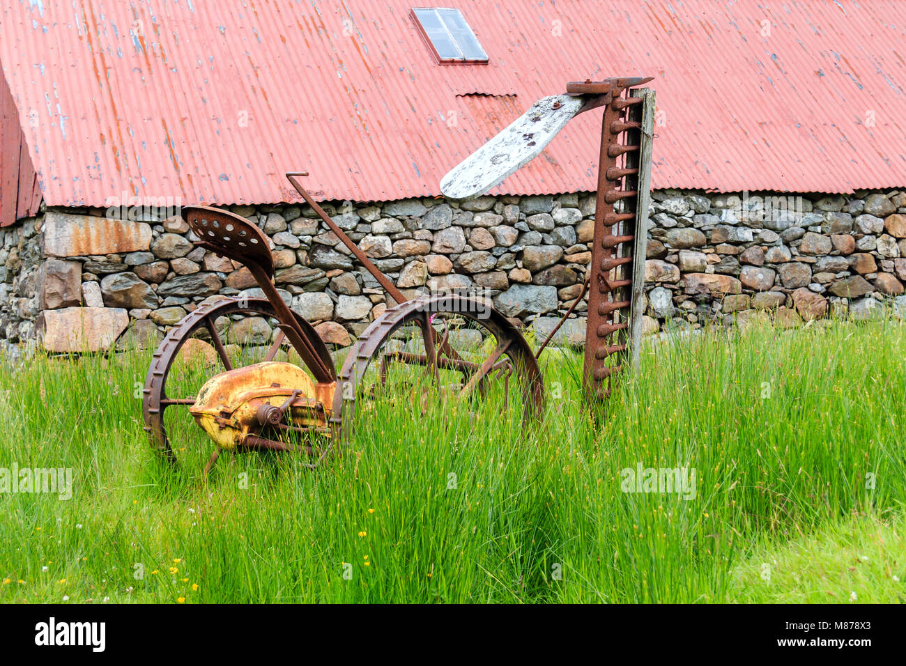 L'annata agricola la falciatura di erba macchina parcheggiata in erba lunga Foto Stock