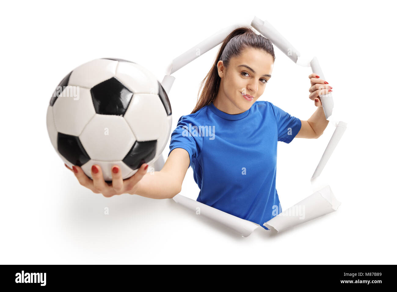 Calcio femminile player rottura attraverso la carta e che mostra un campo di calcio Foto Stock