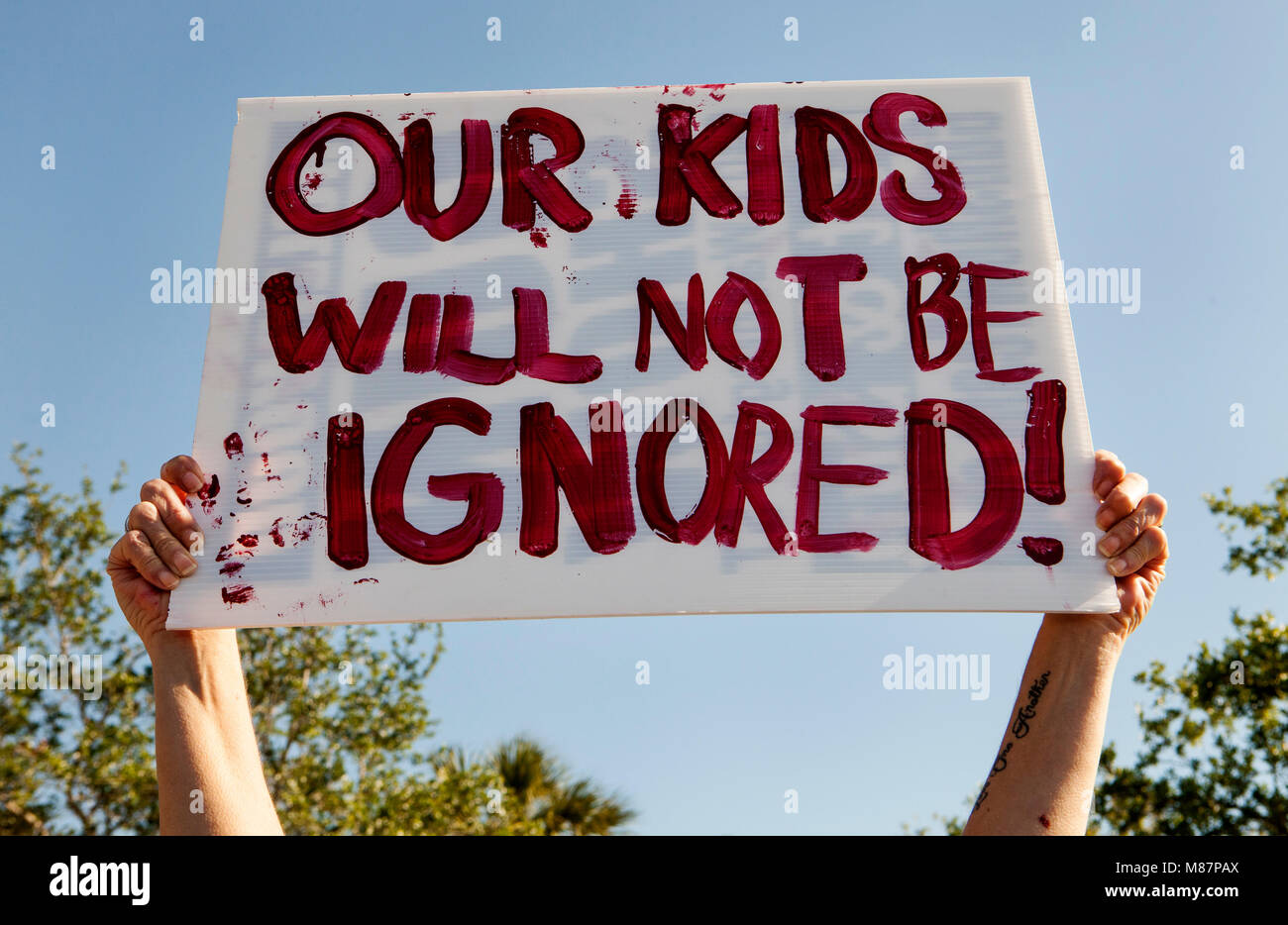 Gli studenti da Marjory Stoneman Douglas High School walkout dalla scuola di onorare il 17 vittime uccise presso la scuola un mese fa il giorno di San Valentino. Foto Stock