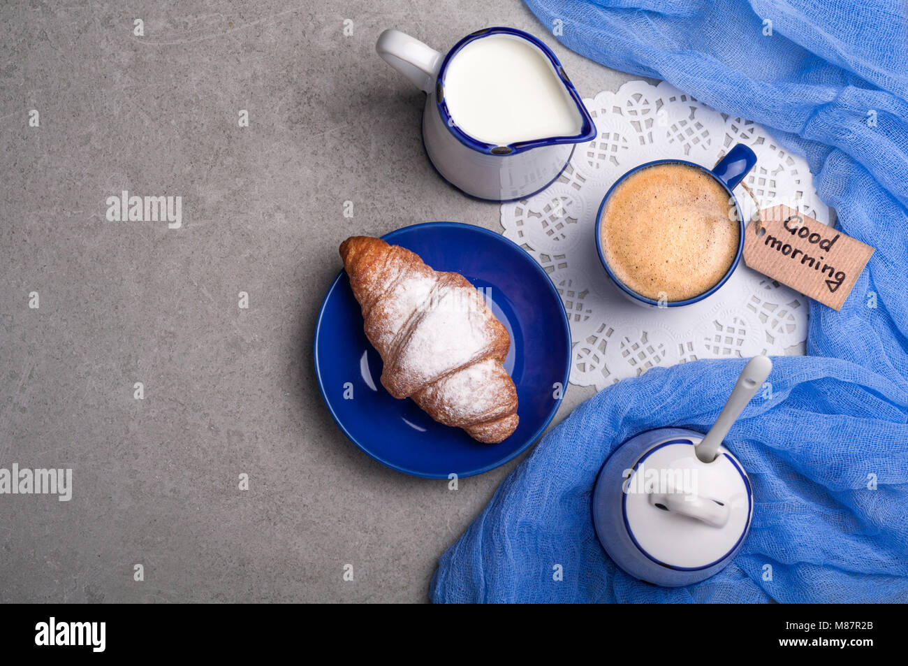 La prima colazione con tazza di caffè, croissant e prendere nota di buon mattino. Vista dall'alto. Spazio di copia Foto Stock
