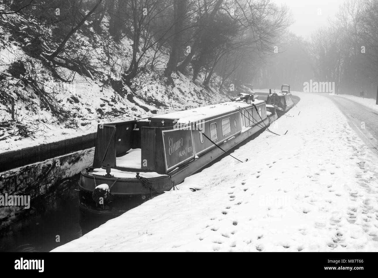 Narrowboats ricoperta di neve si vedono ormeggiati in Llangollen Canal nel tardo inverno Foto Stock